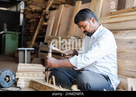 Indischer Zimmermann, der Holzdesign mit Schreinerei-Werkzeugen am Arbeitsplatz macht - Konzept der qualifizierten Beschäftigung, Kreativität und lokalen Handwerkern. Stockfoto