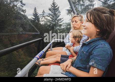 Mutter mit zwei Söhnen, die in der Seilbahn fahren, Österreich Stockfoto