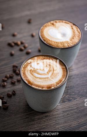 Zwei Tassen Kaffee Latte Art auf dem Holzschreibtisch Stockfoto