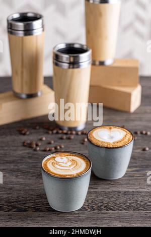 Zwei Tassen Cappuccino mit Latte Art auf einem Holztisch Stockfoto