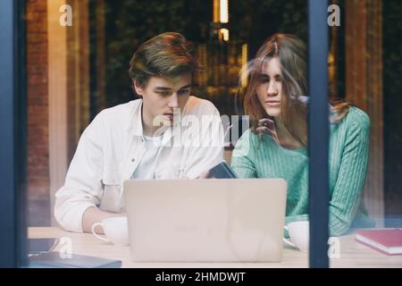 Nachdenkliches Paar, das im Café an einem Laptop arbeitete Stockfoto