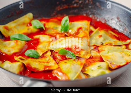 Ravioli-Pasta mit Tomatensauce, Oliven und Basilikum Stockfoto