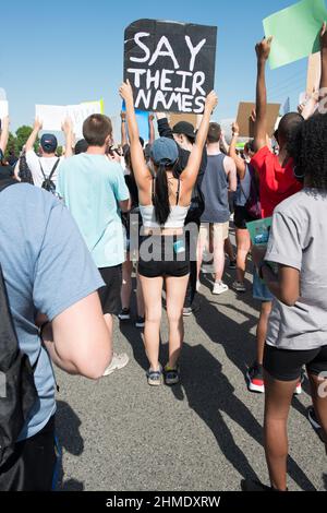 Eine Protesterin in der Black Lives Matter-Protestaktion in Sterling Heights, Michigan, hält ein Schild mit der Aufschrift „SAY THEIR NAMES“ hoch. Stockfoto