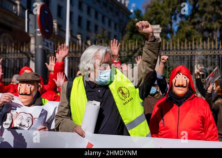 Madrid, Spanien. 09th. Februar 2022. Ein Protestler ruft während eines Protestes Slogans. Eine Gruppe von Rentnern und Mitgliedern der Plattformen und Gruppen von COORPENMADRID-COESPE versammelten sich vor dem Hauptsitz der Bank of Spain in Madrid, bekleidet in 'Casa de Papel'-Kostümen, um auf der Nachfrage nach fairen, anständigen und ausreichenden öffentlichen Renten zu demonstrieren. Kredit: SOPA Images Limited/Alamy Live Nachrichten Stockfoto