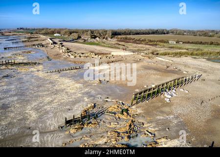 Hölzerne Groynes und die Verteidigung des Meeres an einem Strand in Südengland nach Sturmschäden. Stockfoto