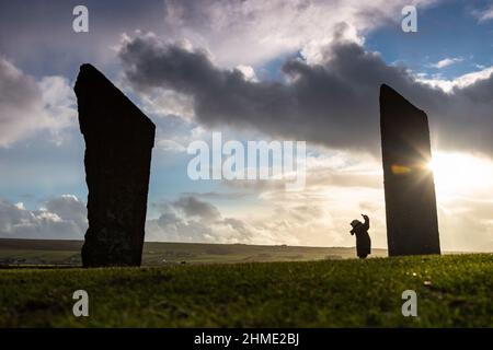 Stenness, Orkney, Großbritannien. 9th. Februar 2022. Ein einnehmender Besucher der Stones of Stenness - einem neolithischen Steinkreis - in Orkney, Schottland, trotzt dem eiskalten Wind am späten Nachmittag. Kredit: Peter Lopeman/Alamy Live Nachrichten Stockfoto