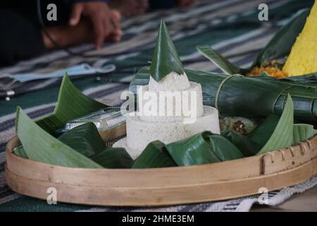 Indonesisches Dankesmenü mit dem Namen Nasi tumpeng (Reis mit Kegelform). Nasi tumpeng essen in der Regel auf Geburtstagsparty, Abschlussfeier oder Danksagn Stockfoto