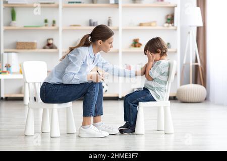 Verärgert kleiner Junge weint im Büro des Psychologen nicht in der Lage, Emotionen zu kontrollieren, teilen Probleme und Traumata Stockfoto