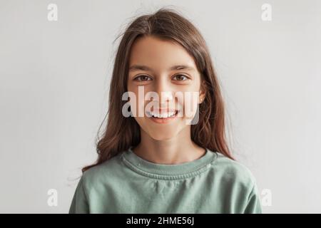 Headshot Von Happy Girl Smiling Looking At Camera, Grauer Hintergrund Stockfoto