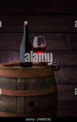 Flasche Rotwein und Weinglas auf Wodden Lauf Stockfoto