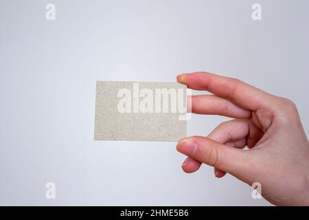 Geschäftsfrau hält leere Karte isoliert auf grauem Wandhintergrund, Modell Visitenkarte Vorlage. Platz für Text kopieren. Stockfoto