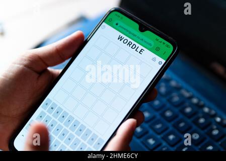 Ein Mann spielt mit dem Wortspiel Wordle aus der Nähe auf einem Handybildschirm auf der offiziellen App-Website in Barcelona, Spanien - 9. Februar 2022. Stockfoto