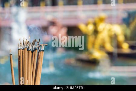 Räucherstäbchen und weißer Rauch in einem Räuchertopf. Es gibt viel Rauch. Kopierbereich, selektiver Fokus. Stockfoto