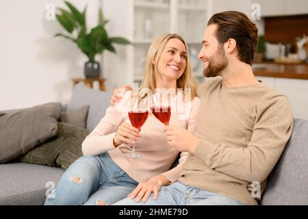 Harmonisches Ehepaar mit Wein mit romantischen Datum, Ruhe nach dem Arbeitstag zu Hause, verbringen Zeit zusammen. Ehepartner feiern wichtiges Datum, Jahrestag Stockfoto