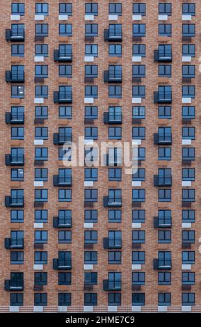 Hintergrundbild - ein Fragment der Wand eines mehrstöckigen Gebäudes mit Balkonen und Fenstern. Stockfoto