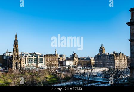 Blick über die Princes Street Gardens mit dem Scott Monument und dem Balmoral Hotel an einem sonnigen Tag mit blauem Himmel, Edinburgh, Schottland, Großbritannien Stockfoto