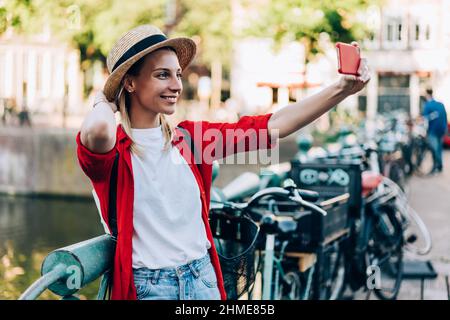 Fröhlicher junger Reisender, der Selfie auf dem Smartphone gemacht hat Stockfoto