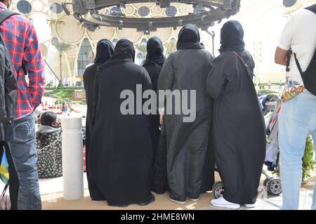 Frauen mit traditioneller muslimischer schwarzer Kleidung auf der Al Wasl Plaza auf der Expo 2020 Dubai, Vereinigte Arabische Emirate - 1. Februar 2022. Stockfoto