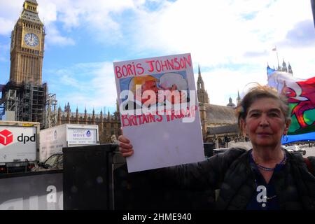 London, Großbritannien, 9th. Februar 2022. Ein Anti-brexit-Protestler hält ein Plakat, das den britischen Premierminister Boris Johnson kritisiert und darauf hindeutet, dass er wie der frühere US-Präsident Donald Trump gegenüber dem Unterhaus sei. Stockfoto