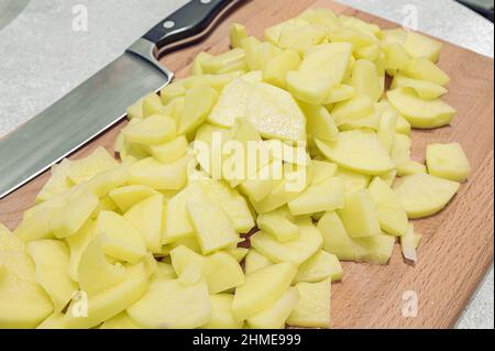 Kartoffelscheiben auf einem alten Holzbrett als Nahaufnahme; selektiver Fokus. Stockfoto