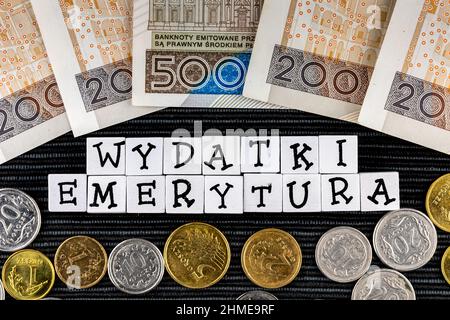 Die Formulierung "wydatki emerytury" wurde übersetzt mit "Spesenrenten" und vielen polnischen Münzen und Banknoten auf schwarzem Hintergrund. Neue Steuervorschriften in P Stockfoto