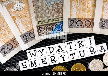 Die Formulierung "wydatki emerytury" wurde übersetzt mit "Spesenrenten" und vielen polnischen Münzen und Banknoten auf schwarzem Hintergrund. Neue Steuervorschriften in P Stockfoto
