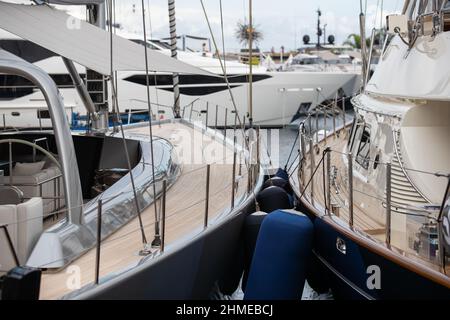 Holzdecks von Segelyachten im klassischen Stil mit Chromgeländer entlang der Kante der Boote in Monaco an sonnigen Tag, hängt eine Menge von Kotflügeln, ein Stockfoto