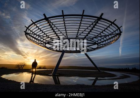 Haslingden, Lancashire, Großbritannien, Mittwoch, 09. Februar 2022. Ein Spaziergänger hält an, um die untergehende Sonne am Halo panopticon über der Stadt Haslingden, Lancashire, nach einem schönen sonnigen Nachmittag zu bewundern. Quelle: Paul Heyes/Alamy News Live Stockfoto