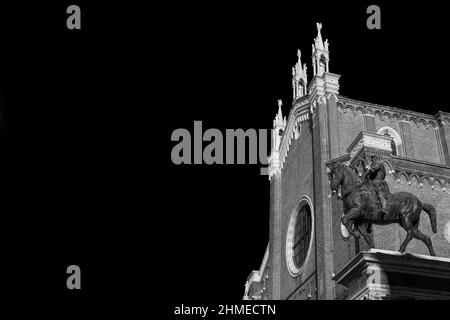 Renaissance-bronzefarbenes Reiterdenkmal der Bartolomeo Colleoni und der gotischen Kirche der Heiligen Johannes und Paul in Venedig (Schwarz-Weiß mit Kopierraum) Stockfoto