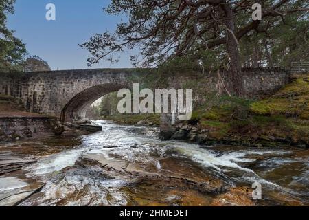 RIVER LUI MAR LODGE ESTATE BRAEMAR SCHOTTLAND GEFÄRBTE FELSEN UND WEISSES WASSER UNTER DER ALTEN STEINSTRASSE BRÜCKE Stockfoto