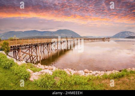 Goldener Sonnenaufgang über dem Shuswap Lake am Salmon Arm Wharf im südlichen Landesinneren von British Columbia, Kanada. Der Kai ist der längste hölzerne Kai in No Stockfoto