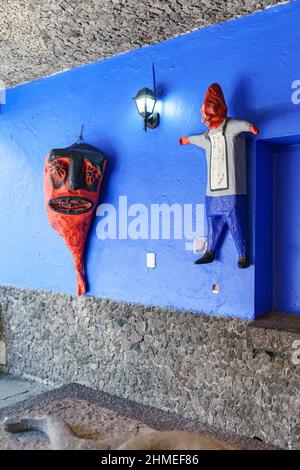 Zwei Papiermaché-Skulpturen hängen an einer blauen Wand im Frida Kahlo Museum, das ihr Haus und Atelier war. Stockfoto