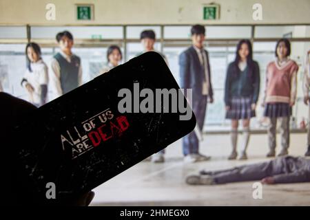 Rheinbach, Deutschland 2. Februar 2022, das Logo der neuen Netflix-Serie 'All of US are Dead' auf dem Display eines Smartphones vor dem Fernseher Stockfoto