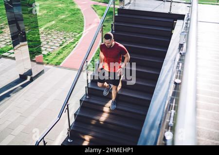 Sportlicher Athlet, der in der Stadt unten läuft Stockfoto