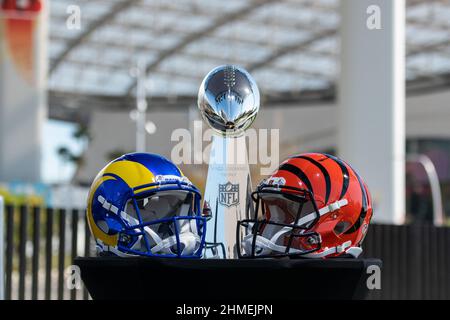 Inglewood, USA. 09th. Februar 2022. Die Helme der Super Bowl Teilnehmer Los Angeles Rams (l) und Cinncinati Bengals stehen auf einem Tisch vor der Vince Lombardy Trophy, die der Gewinner erhält. NFL-Chef Goodell hält vor dem Super Bowl eine Pressekonferenz ab. Quelle: Maximilian Haupt/dpa/Alamy Live News Stockfoto