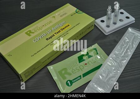 Ottawa, Ontario, Kanada - 9. Februar 2022: Ein Rapid Response COVID-19 Rapid Antigen Test Kit liegt auf einem Holztisch mit einem Teststäbchen. Stockfoto