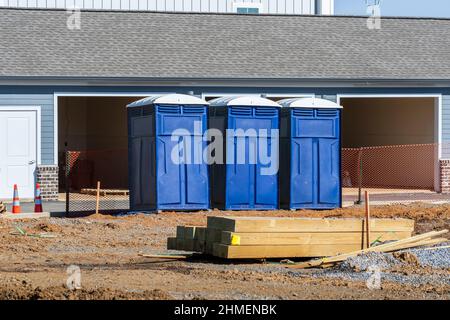 Horizontale Aufnahme von drei porta Töpfchen oder Outdoor-Toiletten auf einer neuen Baustelle. Stockfoto