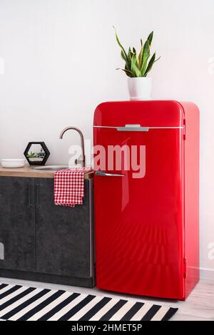 Roter Kühlschrank in der Nähe einer hellen Wand in der modernen Küche Stockfoto