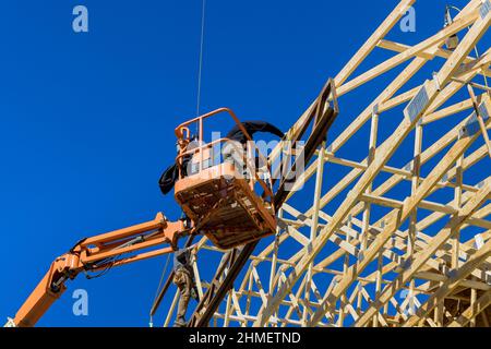 Bauschreinermeister Dachdecker Arbeiter nageln Holzbalken mit Hammer auf Dach Installation Stockfoto