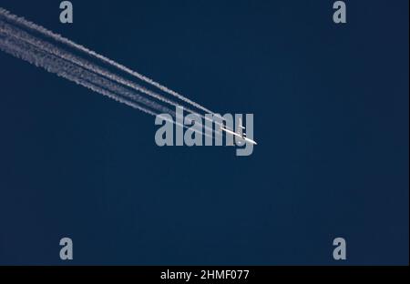 Flugzeug mit vier-Stream-Kondensstreifen gegen blauen Himmel Stockfoto