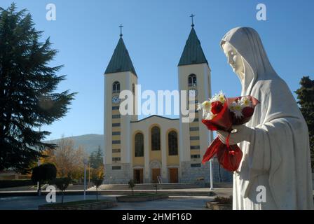 Gesegnete Jungfrau Maria mit roter Rose, Tatue der gesegneten Jungfrau Maria, die eine rote Rose hält, während die St. Jakobskirche in Medjugorje, Bosnien und Herzegowina. Stockfoto