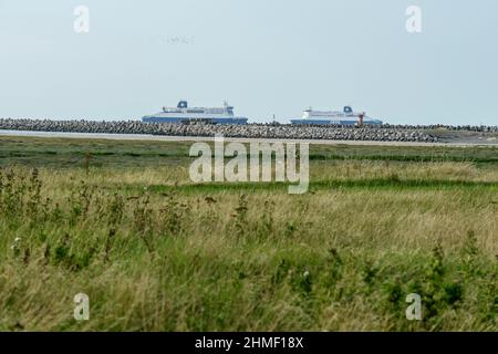 Promeneurs sehen sich einem Grand-Fort Philippe Bikers gegenüber, der das nördliche Meer in Grand-Fort Philippe betrachtet Stockfoto