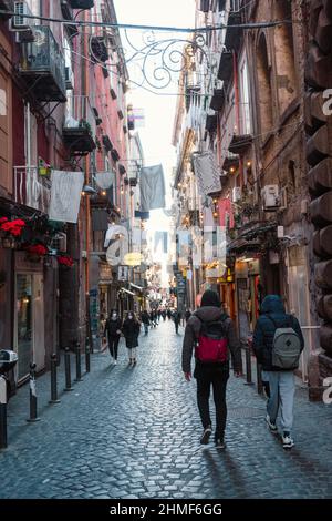 Naples, Italien, 22. Januar 2022: Ikonische schmale Straße in der Innenstadt von Neapel, die Straße voller Menschen und Leben Stockfoto