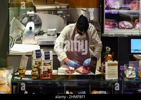 Ein Metzger, der ein Stück Fleisch an der Metzgerei im Coop Concept Store in der Galleria San Federico, Turin, Piemont, Italien, zubereitet Stockfoto