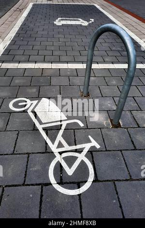 Parkplatz für Lastenräder. Ein auf dem Bürgersteig lackiertes Symbol zeigt ein Lastenrad neben einer Halterung. Hannover, 5. Februar 2022 --- Parkplatz für Lastenräder. Ein auf den Bürgersteig gemaltes Symbol zeigt ein Lastenfahrrad neben einem Befestigungsbügel. Hannover, 5.2.2022 Stockfoto
