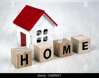 Kleines weißes Holzhaus und Würfel mit der Inschrift Home closeup Stockfoto