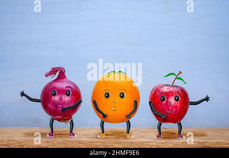 Tanzender Apfel, Orange und Zwiebel, Charaktere, fröhliches, lustiges Gemüse- und Obstkonzept, mit Kopierraum Stockfoto