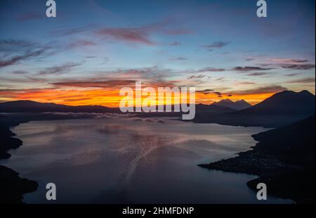 Sonnenaufgang über dem Lake Atitlan und Fuego, Vulkan, Lago Atitlan, Guatemala Stockfoto