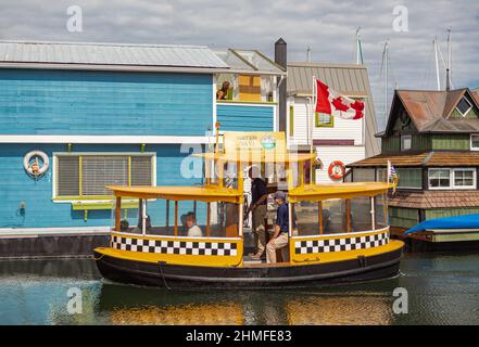 Floating Home Village Bunte Hausboote und Wassertaxi. Fisherman's Wharf Reflection Inner Harbour, Victoria BC, Kanada Pazifischer Nordwesten. Bereich hat f Stockfoto