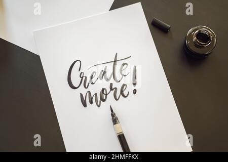 Mehr Creat. Kalligraph junge Frau schreibt Phrase auf weißem Papier. Einschreibender ornamental verzierten Buchstaben. Kalligrafie, Grafik Design, Beschriftung Stockfoto